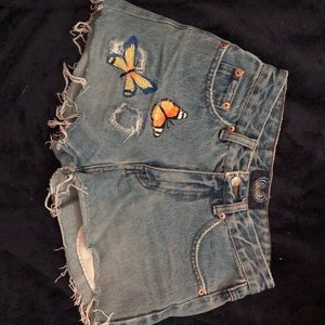 Women’s destroyed jean butterfly detail shorts.